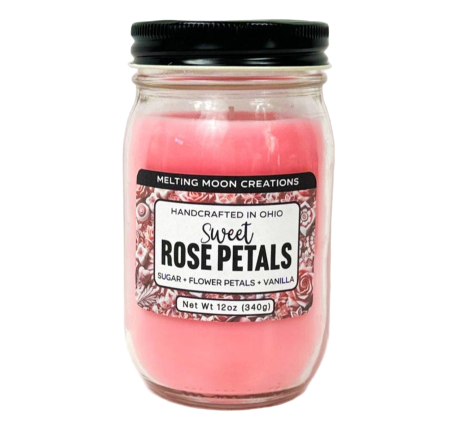 Sweet Rose Petals candle in glass jar with black twist on lid on white background. Pink candle wax. Candle label designed by Melting Moon.