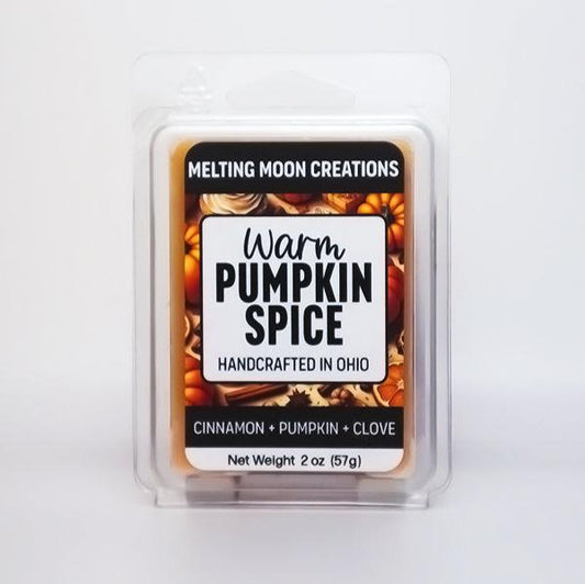 Warm pumpkin spice wax melt sitting on white backdrop. Label designed by Melting Moon Creations.